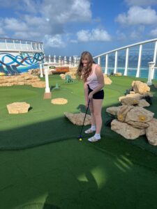 Child playing mini golf on cruise ship.