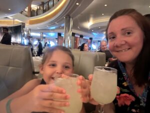 Mother and daughter drinking lemonade on cruise ship;