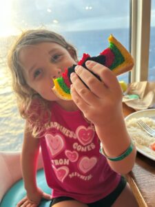 Child eating coloured bread on Royal Caribbean Cruise.