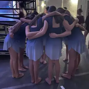 Group of dancers gathered back stage at dance competition.