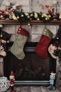 Festive Christmas stockings hanging on a decorated fireplace mantel.
