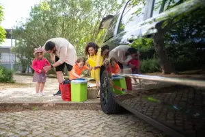 A family prepares for a joyful picnic outing in a sunny park with a black car, reflecting happiness and bonding.