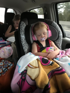Child sleeping comfortably on road trip.