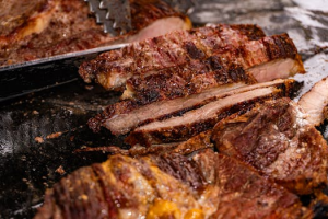 Close-up of sliced grilled beef with rich seasoning at a traditional Brazilian barbecue in Londrina.