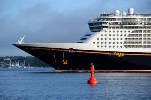 Close-up of the Disney Dream cruise ship docked in Deutschland, capturing its grandeur against a calm sea.