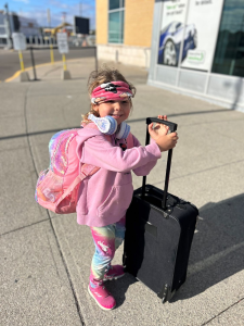 Child heading on trip with suitcase and luggage.